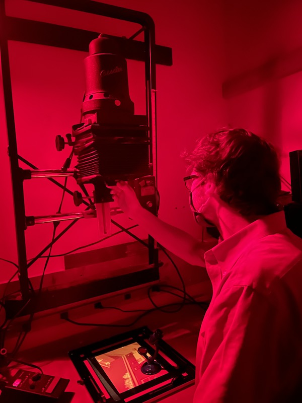 Person using the Beseler 45 MXII enlarger in the black and white darkroom